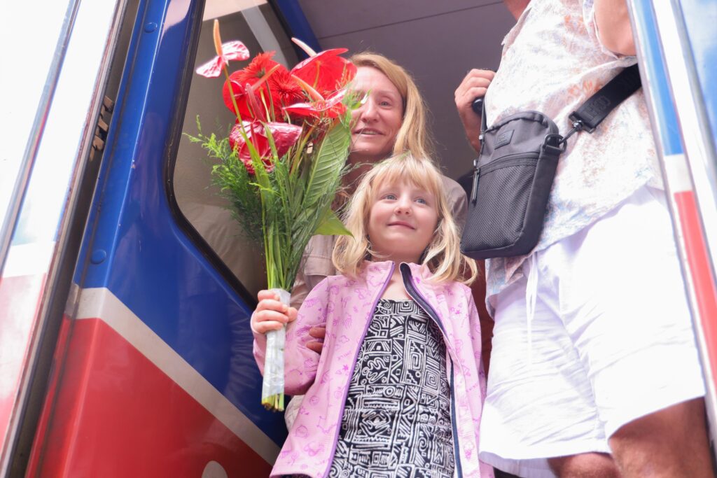 Tourists holding flowers in the first train